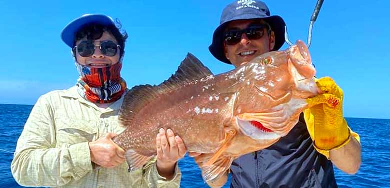 Two Friends Holding Fish | FishyBizness Fishing Charters & Boat Tours in Naples, Florida